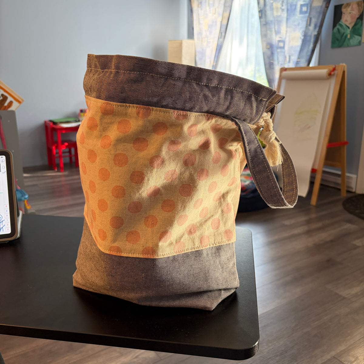 Pink polka-dot drawstring project bag with inner slip pockets and strap handle