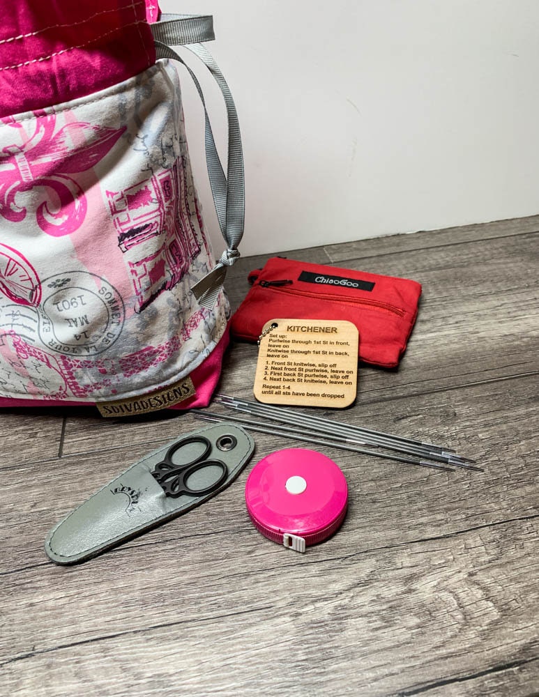 Sock knitting bag with drawstring closure and inner dividing zippered pocket and snap tabs to keep yarn from tangling